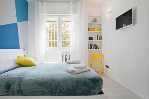 - une chambre avec un lit et une chaise jaune dans l'établissement University of Bologna & Porta San Donato Apartment, à Bologne