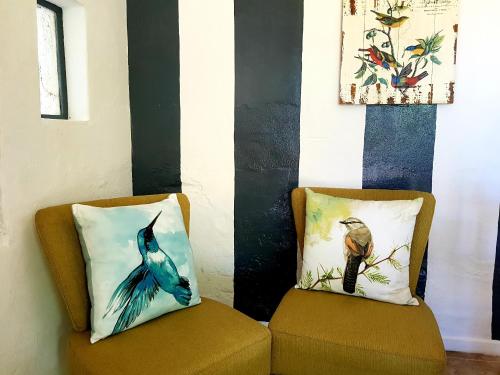 a living room with two couches and a painting on the wall at De Molen Guest House in Somerset West