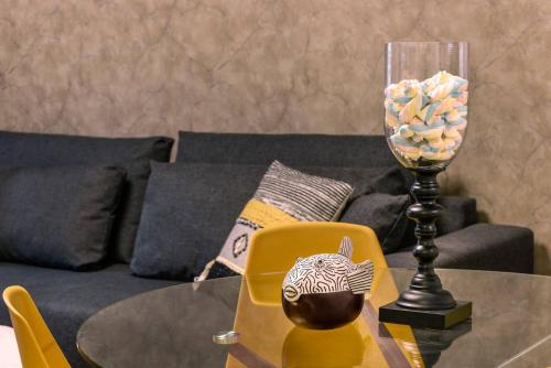 a glass vase on a table with a yellow chair at Havatselet 19 By Isrentals in Jerusalem