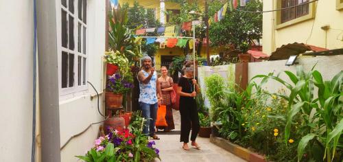 a group of three people standing in a garden at Yog Hostel- Rooftop Yoga & Backpacker Social Stay in Thamel, Kathamndu in Kathmandu