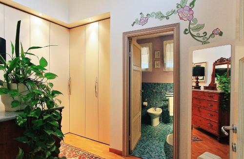 a bathroom with a toilet and a plant in it at Il Fiore all'Occhiello in Lucca