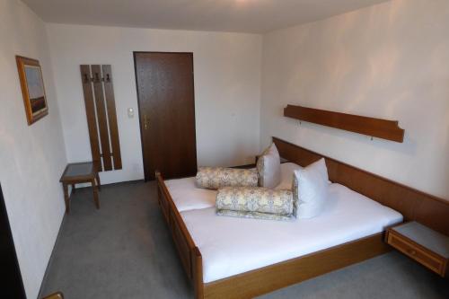 a room with a bed with white sheets and pillows at Haus Alois Nußbaumer jun. in Saalfelden am Steinernen Meer