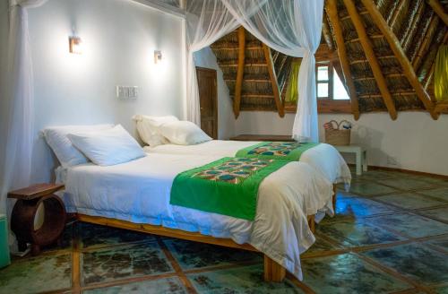 een slaapkamer met een bed in een kamer bij Bungalow Tucul in Vilanculos