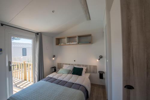 Un pat sau paturi într-o cameră la Camping Les Grenettes