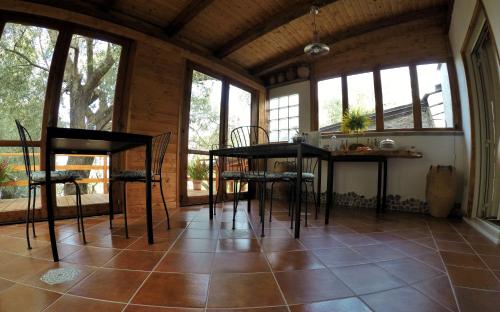 a kitchen with a table and chairs in a room with windows at Dimora degli Ulivi in Caprioli