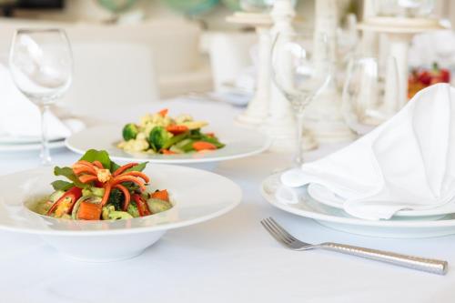 een witte tafel met borden en wijnglazen bij Mia Beach, beach villa and events in Chaweng Beach