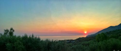 a sunset over a body of water with the sun setting at Dimora degli Ulivi in Caprioli