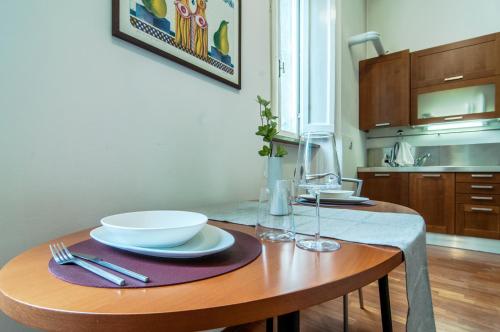 a table with plates and bowls on it in a kitchen at Umbrian Concierge - Duomo Accommodations in Perugia