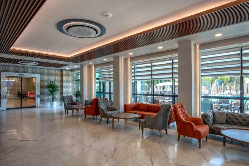 a lobby with couches and chairs and tables and windows at Riviera Zen Hotel Adult Only in Alanya
