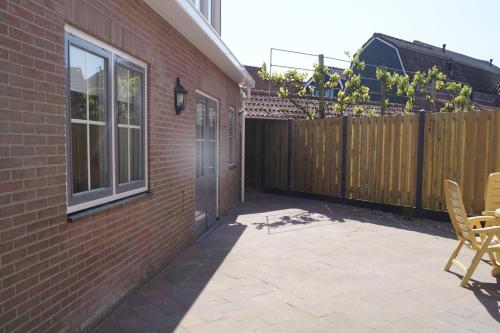 a patio with a wooden fence and a wooden door at Ons Kotje in Aagtekerke