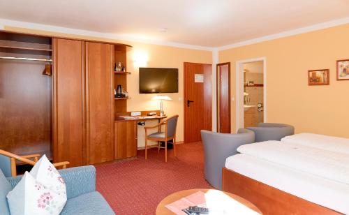 a hotel room with a bed and a desk at Hotel am Katharinenholz in Potsdam
