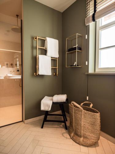 a bathroom with a shower and a chair and towels at Alpenloge Design Hotel in Scheidegg