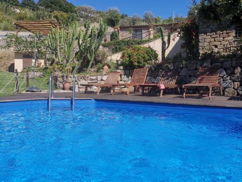 une grande piscine avec des chaises dans l'établissement San Noto Antica Residenza di Caccia, à Ficarra