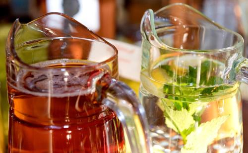 a jug and a glass of tea on a table at Hotel am Katharinenholz in Potsdam