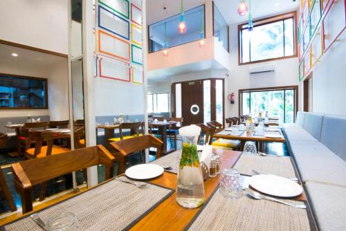 - une salle à manger avec des tables, des chaises et des fenêtres dans l'établissement VITS Sharanam Thane, à Thane
