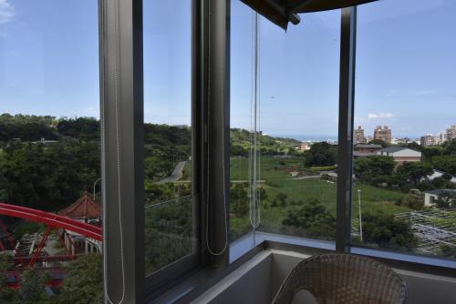 a room with windows with a view of a playground at Rainbow Bridge B&B in Sanzhi