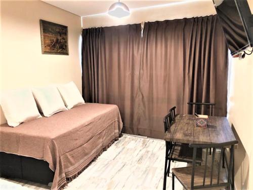 a bedroom with a bed and a table in it at BsAs Platino Apart in Buenos Aires