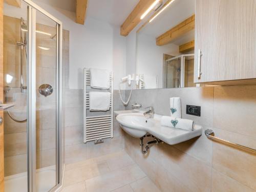 y baño blanco con lavabo y ducha. en Residence Brunello, en Ortisei