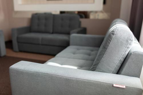 a gray couch in a living room with a couch at Meridian in Karagandy