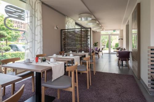 a restaurant with tables and chairs in a room at Hotel Birkenhof in Bad Radkersburg
