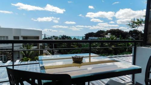 a table on a balcony with a view of the ocean at Arkenstone Studios in La Gaulette