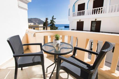 a table and chairs on a balcony with a view of the ocean at Porfyris Studios and Apartments in Karpathos Town
