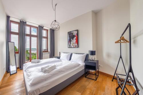 - une chambre avec un grand lit et des draps blancs dans l'établissement Apartamenty Sun & Snow Traugutta Premium, à Sopot