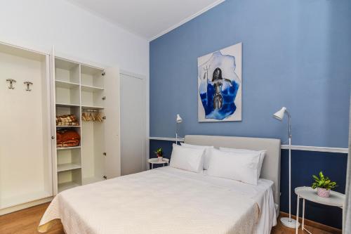 a bedroom with a white bed and blue walls at The Elegant. Spacious city center apartment. in Heraklio