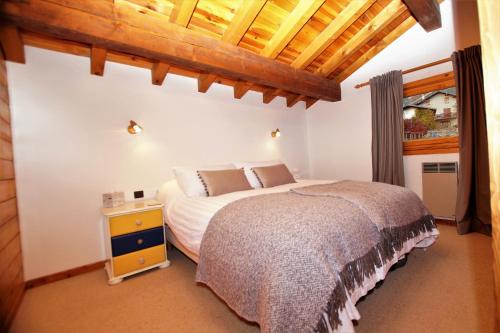 a bedroom with a bed and a wooden ceiling at Chalet du Pre in Séez
