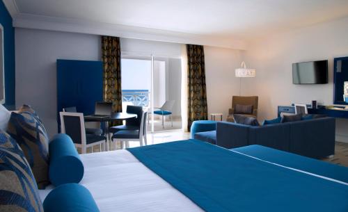 a hotel room with a bed and a living room at Radisson Blu Resort & Thalasso Hammamet in Hammamet