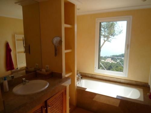 a bathroom with a sink and a window with a tree at Traumvilla Encina in Canyamel