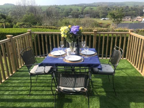 a table with a vase of flowers on a deck at Ballymacdoe Cottage Cushendall in Cushendall
