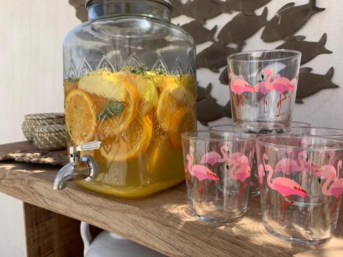 a jar of orange juice and glasses on a table at Lodge Sainte Helene Adult only in Saintes-Maries-de-la-Mer