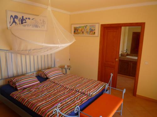 a bedroom with a bed with a net above it at Traumvilla Encina in Canyamel