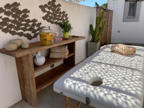 a patio with a bed and a table with a shelf at Lodge Sainte Helene Adult only in Saintes-Maries-de-la-Mer