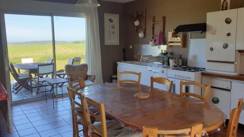 une cuisine et une salle à manger avec une table et des chaises dans l'établissement Chambre d'hôte El Dorado, à Vittefleur