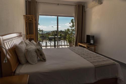a bedroom with a bed with a view of a balcony at Arkenstone Studios in La Gaulette