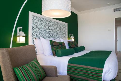 a bedroom with a large bed and a chair at Radisson Blu Resort & Thalasso Hammamet in Hammamet