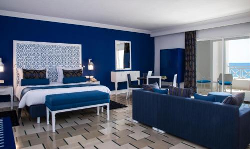 a blue bedroom with a bed and a couch at Radisson Blu Resort & Thalasso Hammamet in Hammamet