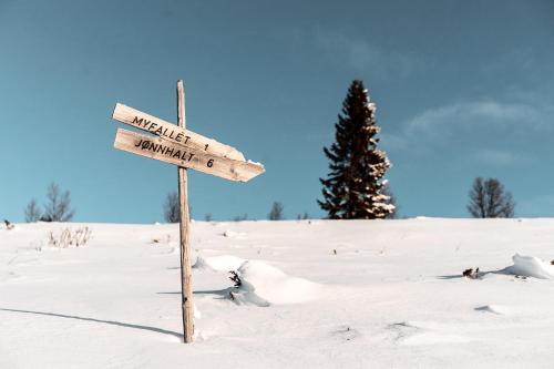 a street sign in a snow covered field at Venabu Fjellhotell in Venabygd