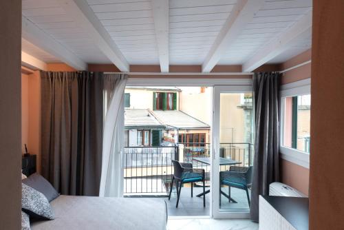 a bedroom with a bed and a balcony with a table at Malbo in Riomaggiore