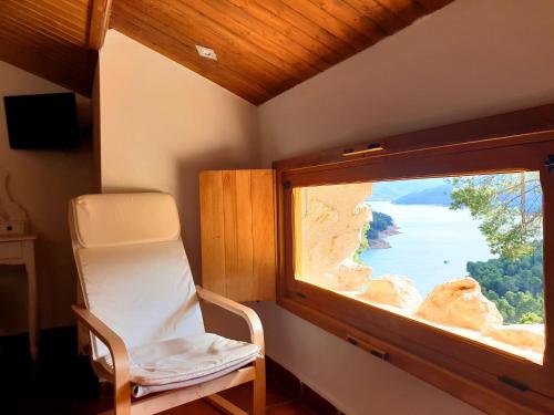 a room with a chair and a window with a view at Casa Rural Los Parrales in El Tranco