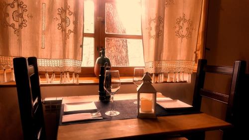 a wooden table with wine glasses and a window at Casa Rural Los Parrales in El Tranco