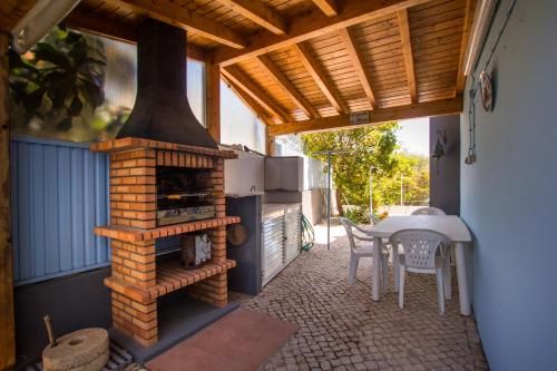 a outdoor patio with a brick oven and a table at Horta's villa - private heatable Pool in Lagos