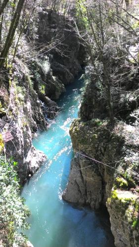 a river with blue water in a rocky canyon at Casotti in Cutigliano