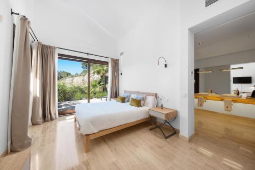 une chambre avec un lit et une grande fenêtre dans l'établissement Villa Diamond by Cap Vermell Estate, à Canyamel