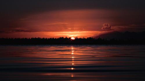 a sunset over a body of water at Arkenstone Studios in La Gaulette