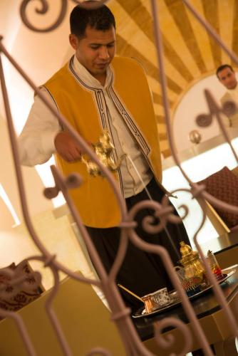 a man standing next to a table with a instrument at Radisson Blu Resort & Thalasso Hammamet in Hammamet