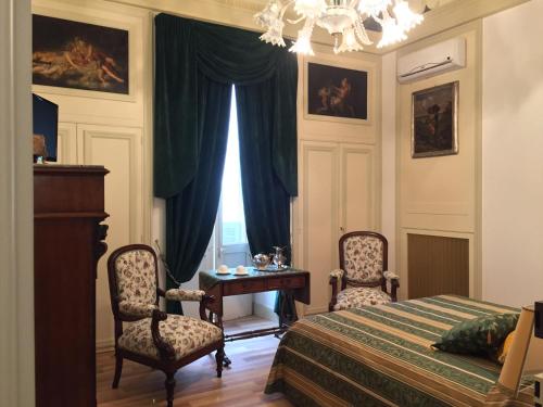 1 dormitorio con 1 cama, 2 sillas y mesa en Palazzo Laguardia, en Fasano