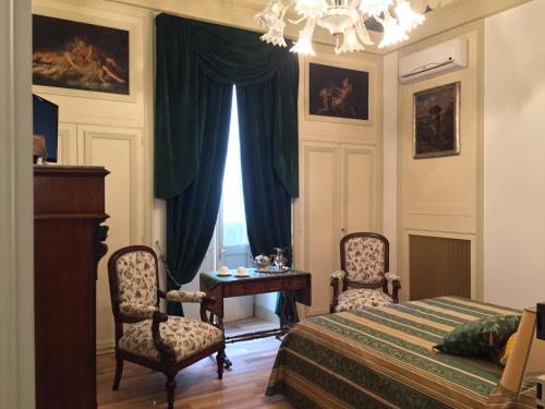 a bedroom with a bed and two chairs and a table at Palazzo Laguardia in Fasano